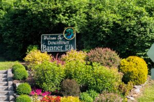 a sign saying "Welcome to downtown Banner Elk" surrounded by beautiful flowers and shrubbery 